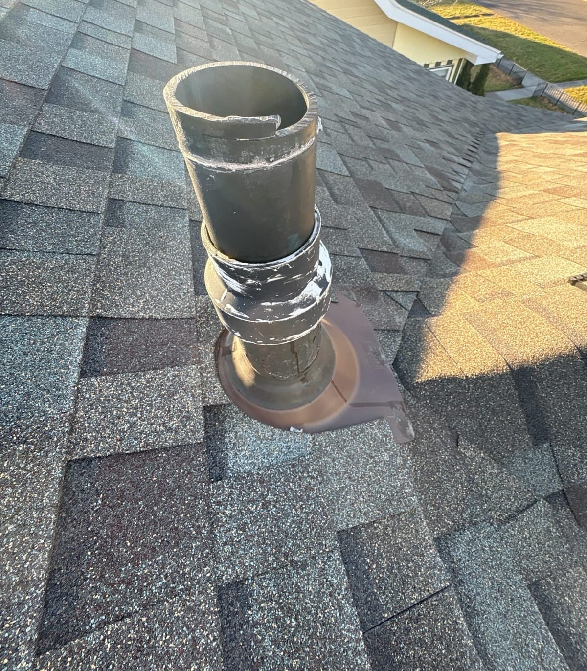 New flashing boot sealed around a cast-iron soil pipe on the roof